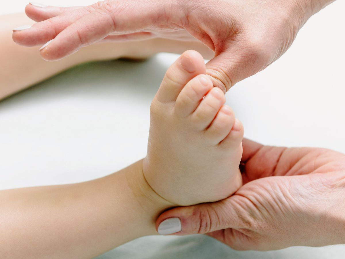 Massage délicat du pied d’un tout-petit
